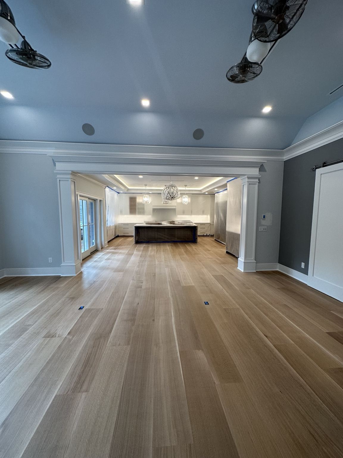 Light wide-plank wood floor in an open room with kitchen island