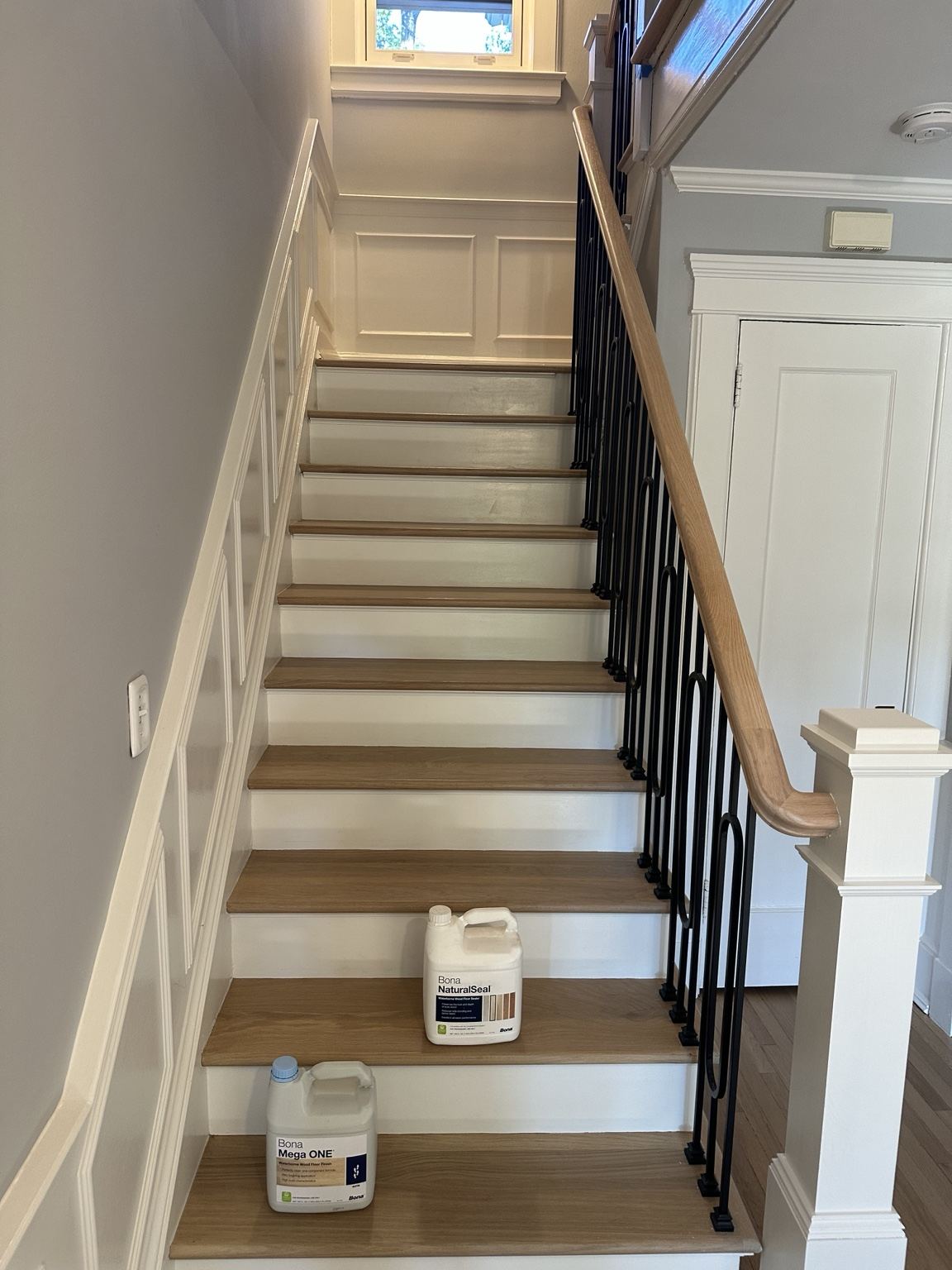 Hardwood staircase with white risers and dark metal balusters