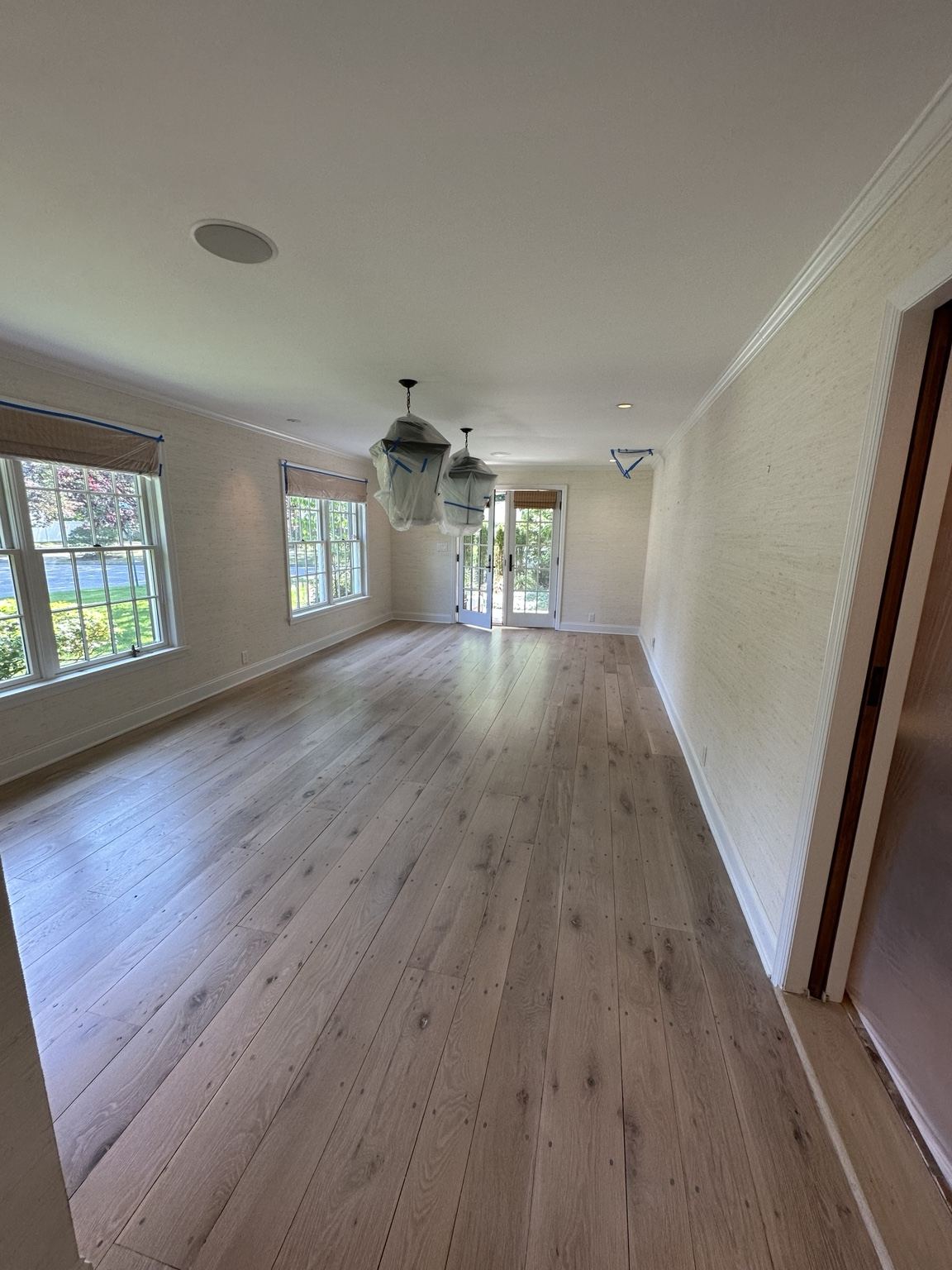 Light plank wood floor in a room with garden windows