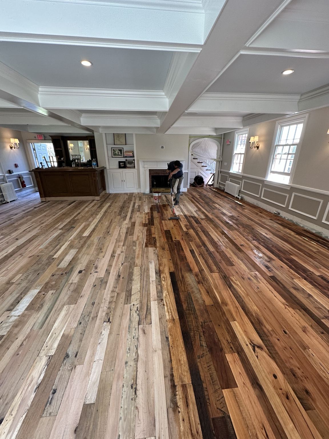 Wood floor with strongly varied board tones in a large room, photographed during on-site work