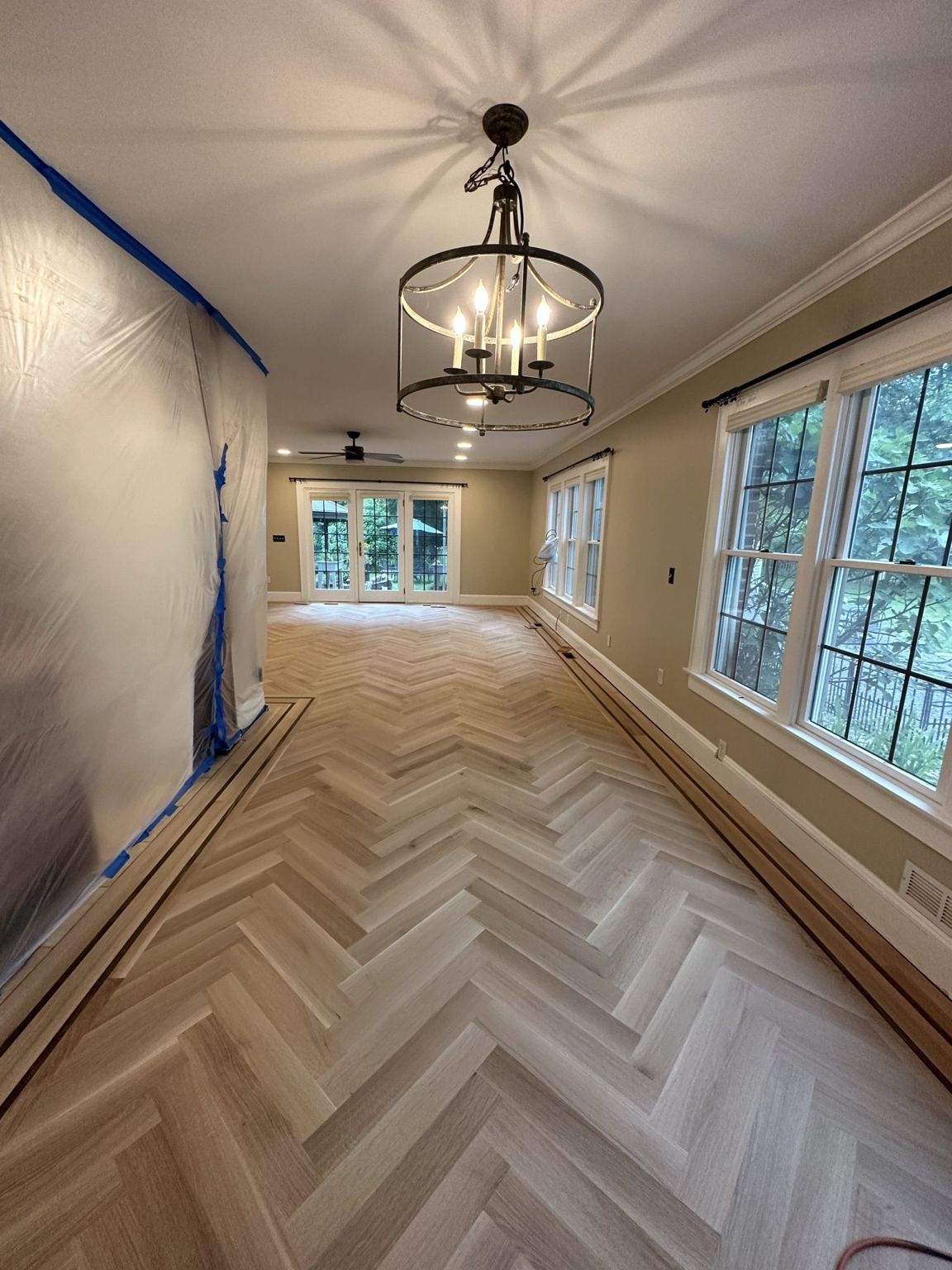 Sanded herringbone field framed by the custom walnut-strip border