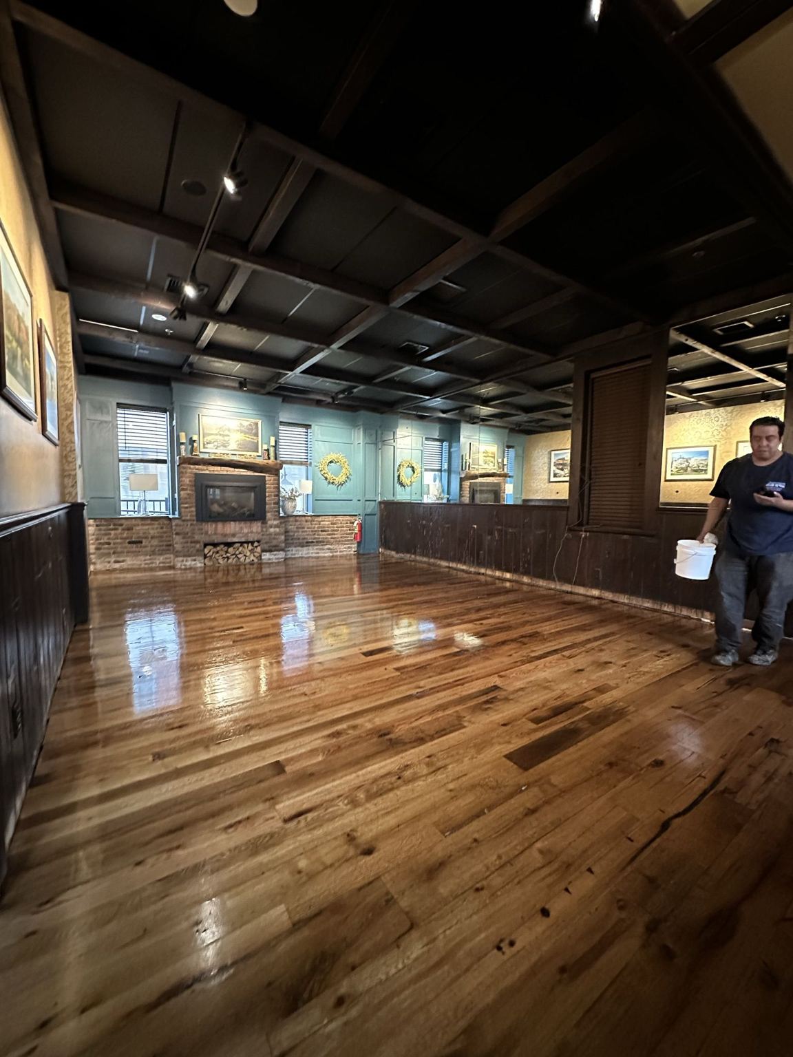 Finished reclaimed hardwood floor in the dark-paneled dining room
